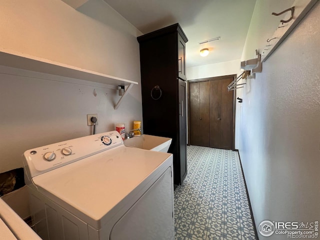 laundry area with hookup for an electric dryer, cabinets, and sink