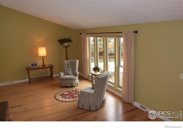 sitting room with a textured ceiling and light hardwood / wood-style flooring