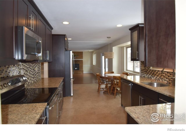 kitchen with hanging light fixtures, dark brown cabinetry, appliances with stainless steel finishes, and backsplash