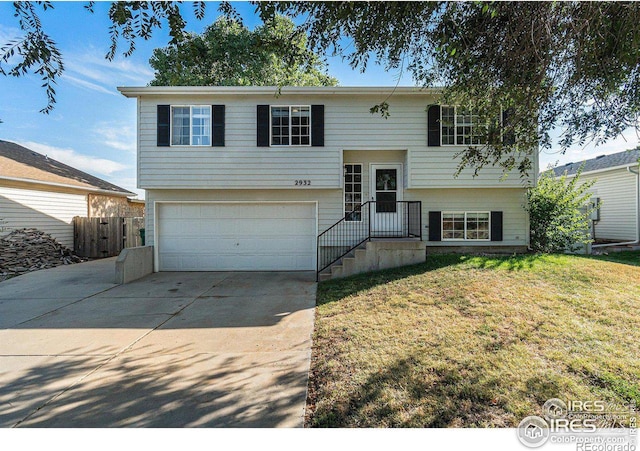 raised ranch featuring a front yard and a garage