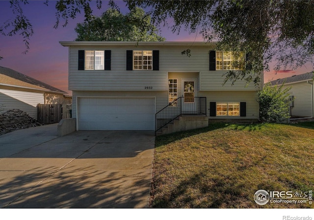 split foyer home featuring a yard and a garage