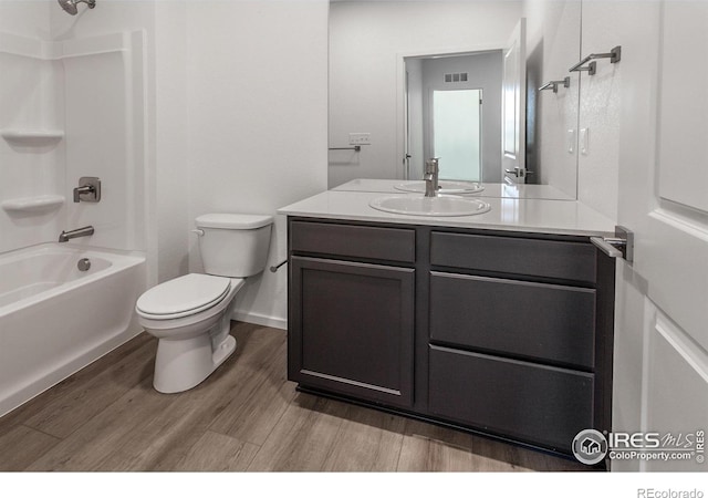 full bathroom with hardwood / wood-style flooring, vanity, shower / bathtub combination, and toilet