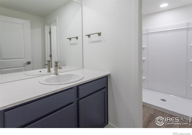 bathroom featuring vanity, hardwood / wood-style flooring, and walk in shower