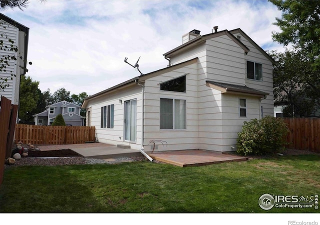 back of house with a patio, a wooden deck, and a lawn