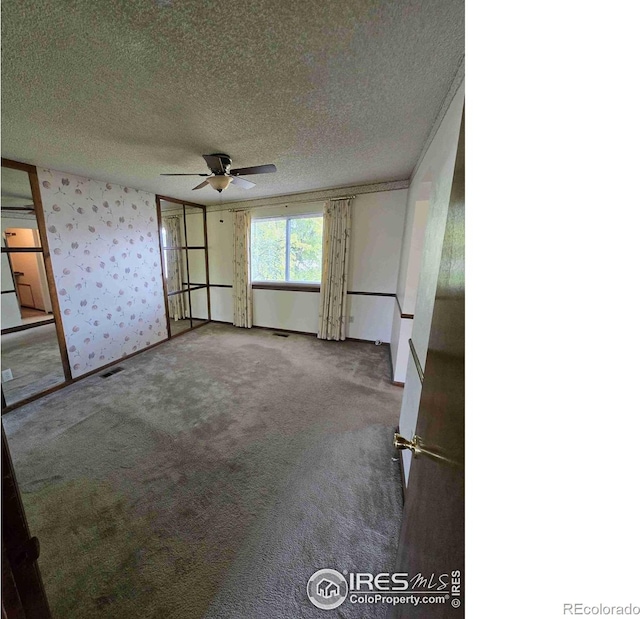 unfurnished bedroom with carpet, ceiling fan, and a textured ceiling