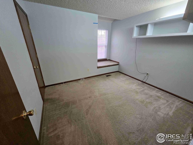 carpeted empty room with a textured ceiling