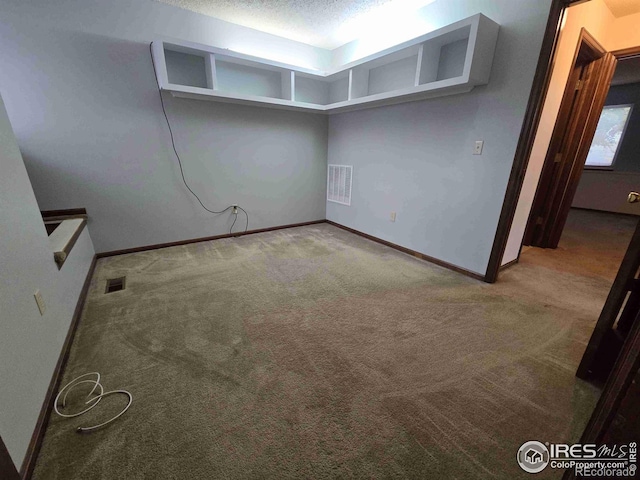 carpeted spare room with a textured ceiling