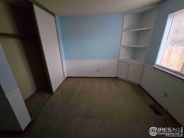 unfurnished bedroom with a closet, carpet flooring, and a textured ceiling