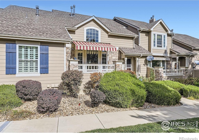 6220 Salvia St, Arvada, CO 80403 - view of front of property featuring roof with shingles, stone siding, and a chimney