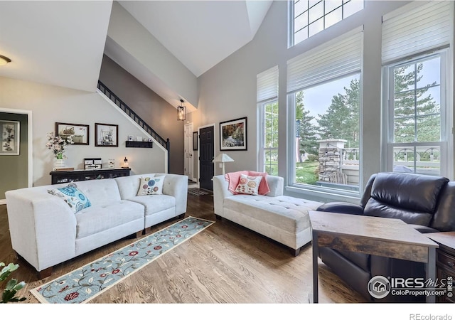 6220 Salvia St, Arvada, CO 80403 - living area featuring plenty of natural light, high vaulted ceiling, wood finished floors, and stairs