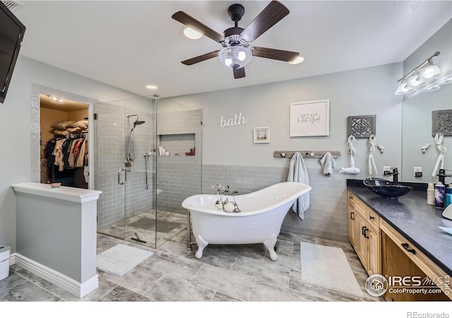 bathroom with vanity, ceiling fan, tile walls, and shower with separate bathtub