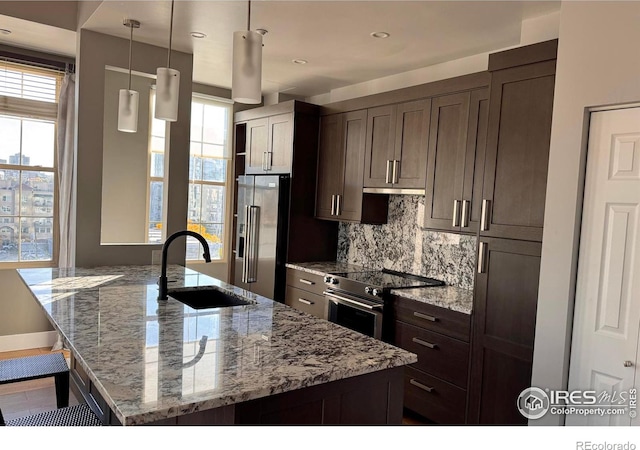 kitchen with light stone counters, appliances with stainless steel finishes, sink, and plenty of natural light