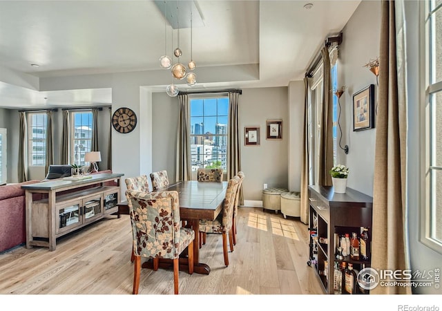 dining area featuring an inviting chandelier, light wood-type flooring, and a wealth of natural light