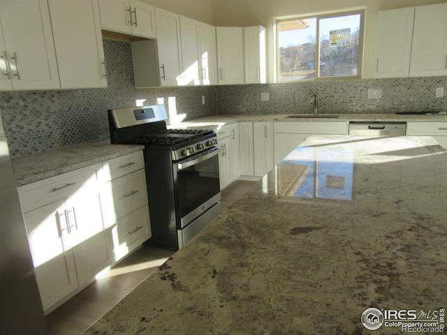 kitchen with decorative backsplash, light stone countertops, and appliances with stainless steel finishes