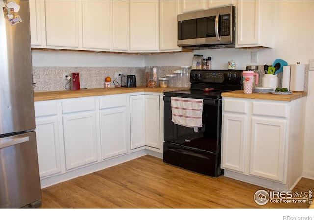 kitchen featuring butcher block countertops, appliances with stainless steel finishes, white cabinetry, and light hardwood / wood-style floors