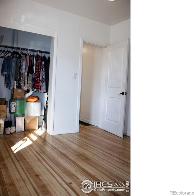 unfurnished bedroom featuring a closet and light wood-type flooring