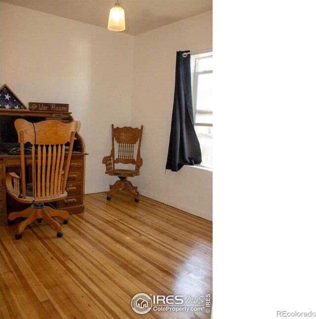 home office with light hardwood / wood-style flooring