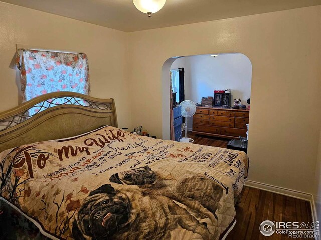 bedroom with dark hardwood / wood-style flooring