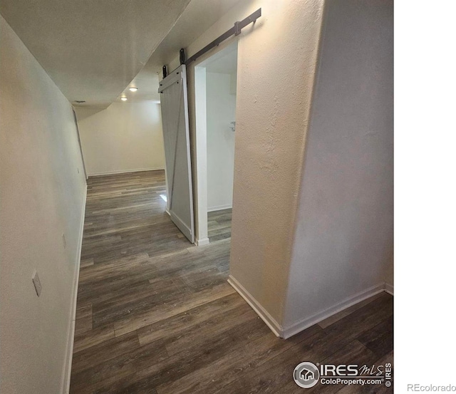 317 Second St, Roggen, CO 80652 - hallway featuring baseboards, a barn door, and wood finished floors