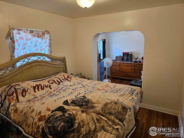 317 Second St, Roggen, CO 80652 - bedroom featuring arched walkways and wood finished floors