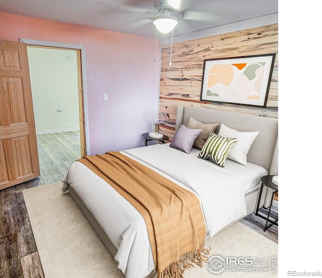 317 Second St, Roggen, CO 80652 - bedroom with ceiling fan, wood walls, and wood finished floors