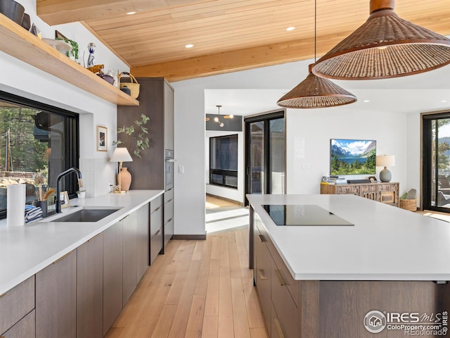 kitchen with vaulted ceiling with beams, wooden ceiling, sink, decorative light fixtures, and light hardwood / wood-style floors