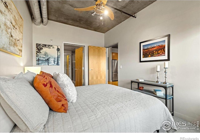 carpeted bedroom with ceiling fan and stainless steel fridge