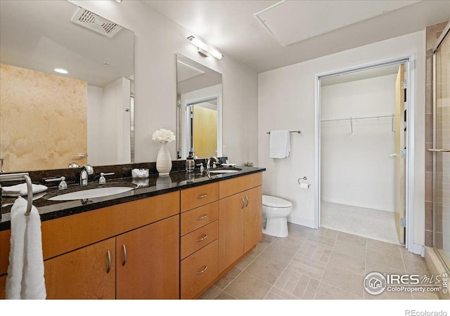 bathroom with tile patterned flooring, vanity, toilet, and an enclosed shower