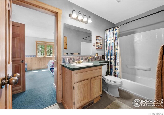743 Hickory Dr, Lyons, CO 80540 - bathroom featuring toilet, vanity, wainscoting, shower / bath combo with shower curtain, and wood walls