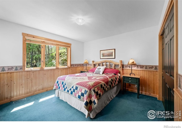 743 Hickory Dr, Lyons, CO 80540 - bedroom with wooden walls, a wainscoted wall, and dark colored carpet
