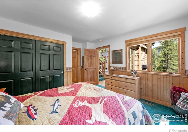 743 Hickory Dr, Lyons, CO 80540 - carpeted bedroom with multiple windows, wooden walls, and a closet