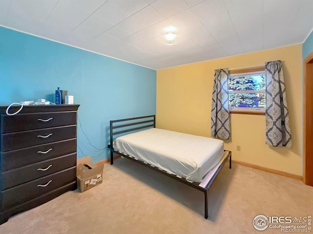 bedroom with baseboards and light colored carpet