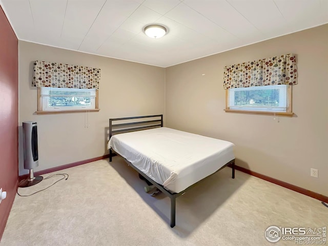 bedroom with carpet floors, multiple windows, and baseboards