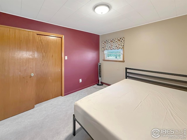 bedroom featuring light colored carpet and baseboards