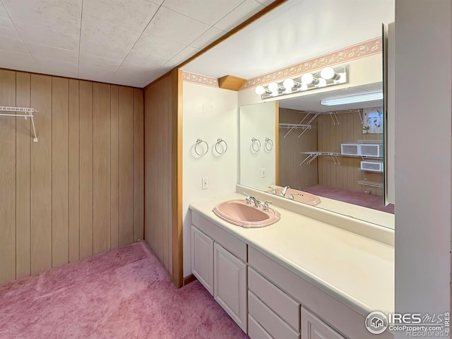 bathroom with vanity and wooden walls