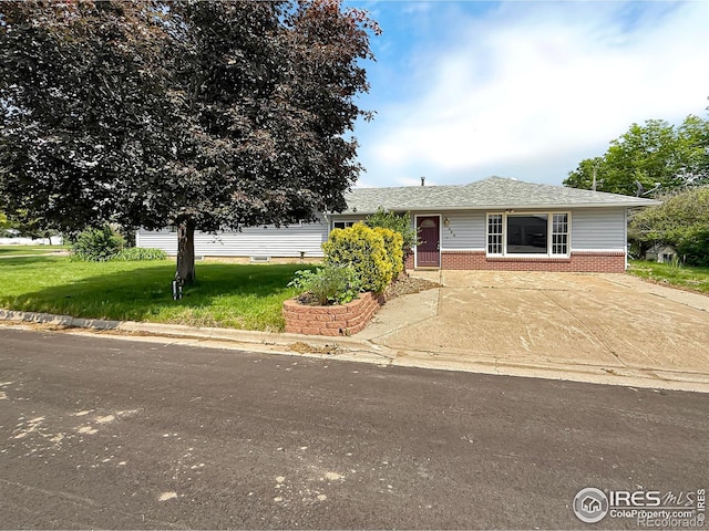 654 W Strohm St, Haxtun, CO 80731 - view of front of house with brick siding, a front lawn, and a shingled roof