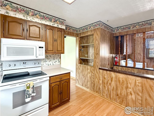 654 W Strohm St, Haxtun, CO 80731 - kitchen with white appliances, light wood-style floors, light countertops, and brown cabinets