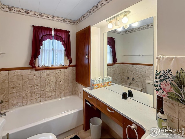 654 W Strohm St, Haxtun, CO 80731 - bathroom featuring a garden tub, vanity, wainscoting, and tile walls