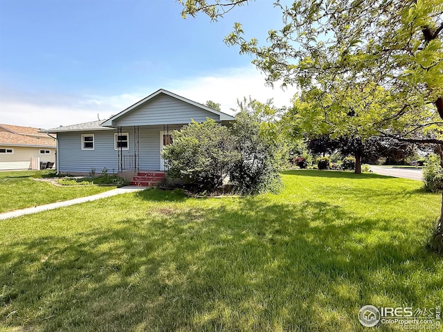 654 W Strohm St, Haxtun, CO 80731 - view of front facade featuring covered porch and a front lawn