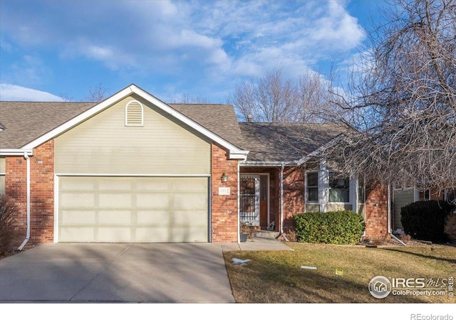 ranch-style home featuring an attached garage, brick siding, driveway, roof with shingles, and a front lawn