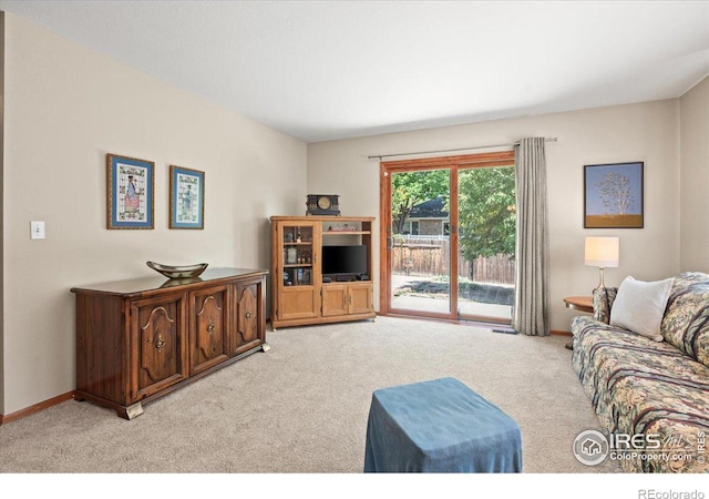 living room featuring light carpet and baseboards