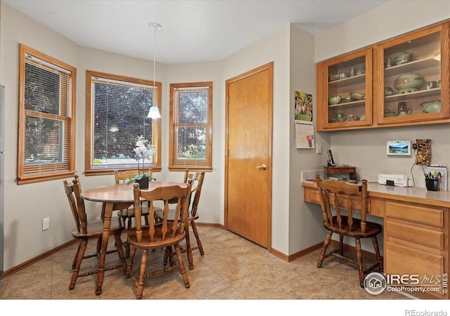 dining area with baseboards and built in study area