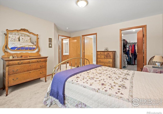 carpeted bedroom featuring a closet and a walk in closet