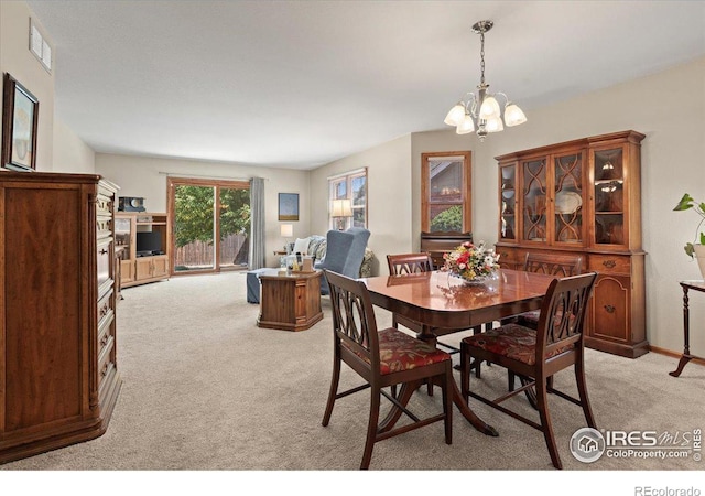 dining space featuring a chandelier, light carpet, and visible vents