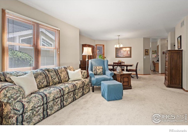 living area with visible vents, a chandelier, and light colored carpet