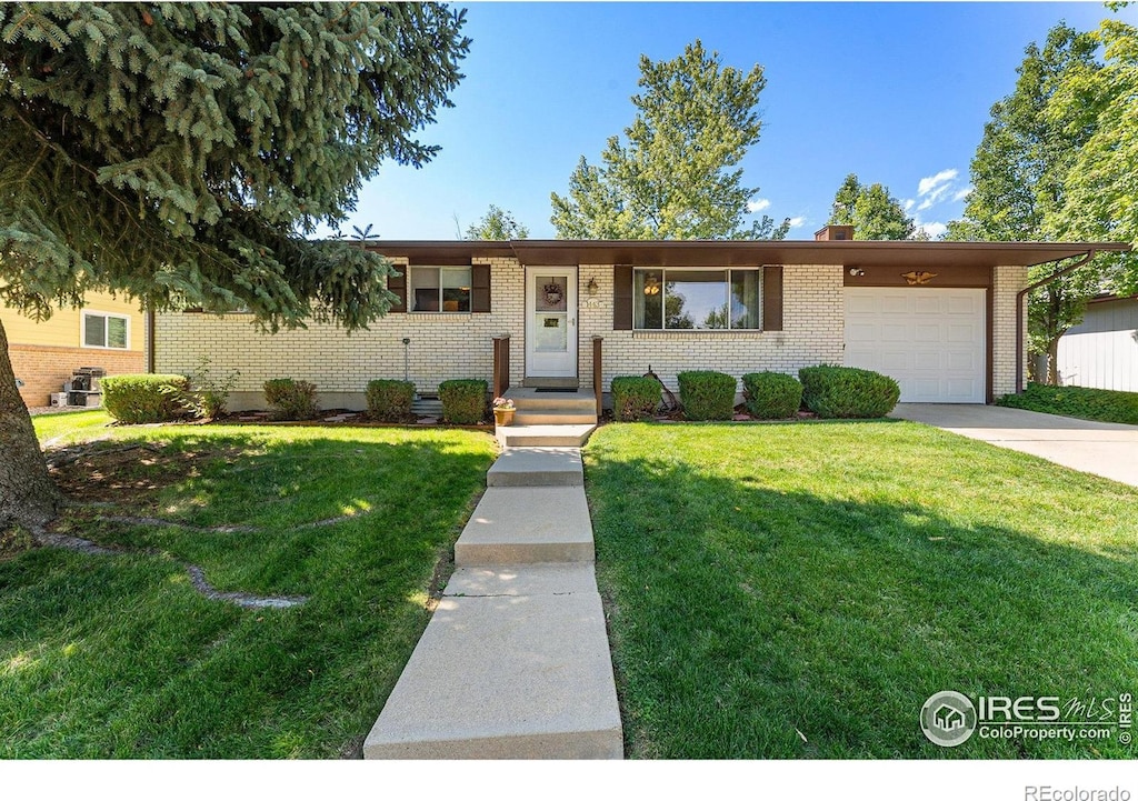 view of front of house with a garage and a front lawn