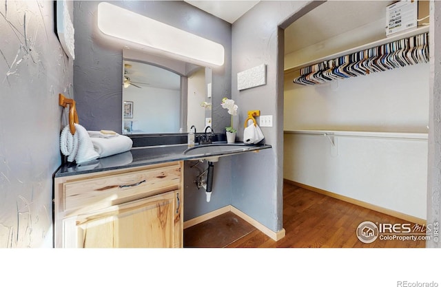 interior space featuring hardwood / wood-style floors, vanity, and ceiling fan