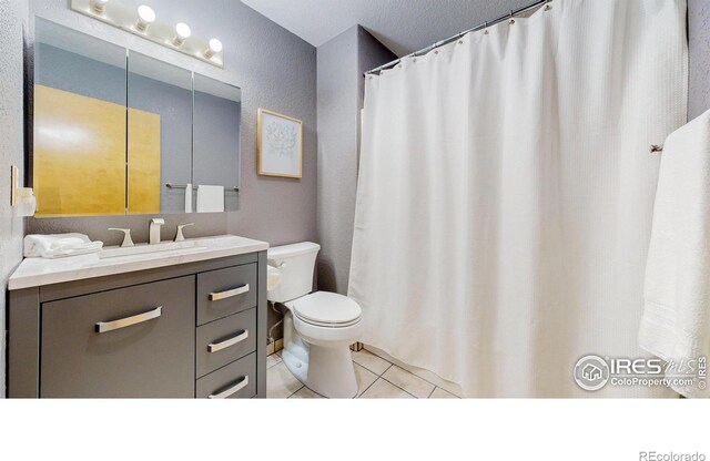 bathroom featuring a shower with shower curtain, a textured ceiling, vanity, tile patterned floors, and toilet