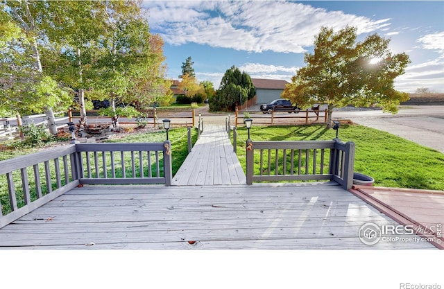 wooden deck featuring a lawn