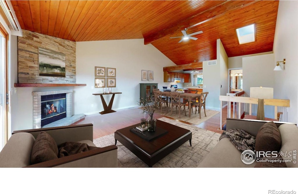 living room with a fireplace, ceiling fan, wood ceiling, and lofted ceiling with skylight